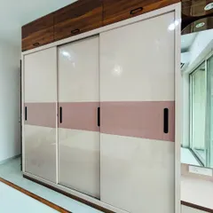 A sleek sliding wardrobe perfect for contemporary bedrooms. This design features a two-tone finish with a soft pink accent band and is complemented by a dark wood-finish loft, maximizing vertical storage space.