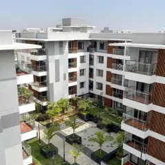 An aerial perspective of the Sona Vistaas residential cluster in Bengaluru, where buildings are organized around a central, verdant courtyard. This layout is a core principle of my township planning, designed to enhance microclimates and create a shared sense of place.