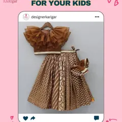 A brown brocade lehenga paired with a dramatic ruffled net top. This is a unique and fashionable ethnic outfit for a child.
