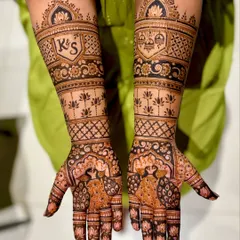 A personalized bridal mehendi with the couple's initials "K S" in a crest, peacock motifs, and a depiction of the wedding ceremony (varmala).
