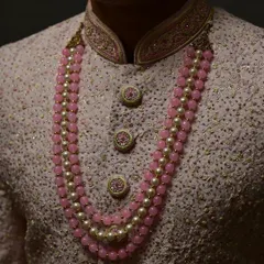 The details matter. A look at the custom buttons and the beautiful pearl mala that completes this groom's outfit.