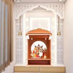 The same wall-niche pooja mandir design, showcasing the detailed craftsmanship and the serene atmosphere created by the soft backlighting.