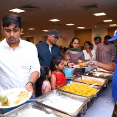Guests, including families with children, line up to enjoy the variety offered at our buffet during a party.