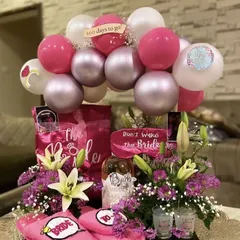 A fun and fabulous hamper for the bride-to-be. This tray is packed with goodies like "Bride" slippers, a "Don't Wake the Bride" sign, a bottle of bubbly, and a balloon garland counting down "100 days to go".