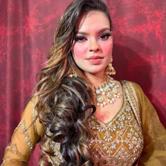A full view of this stunning 90s-inspired royal glam look. The focus is on dramatic, kohl-rimmed eyes, beautifully highlighted skin, and voluminous hair, perfect for a sangeet or reception.