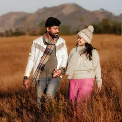 Walking hand-in-hand through a field of golden grass, this couple's pre-wedding photo captures a sense of journey and togetherness against a beautiful mountain backdrop.