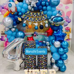 An out-of-this-world astronaut theme for a 4th birthday. This party features a balloon arch with rocket and planet elements, astronaut figures, and custom-printed space-themed plinths.