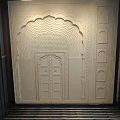 This intricately carved stone panel replicates the grandeur of a traditional Indian jharokha and doorway. It's a perfect example of how we use modern techniques to honor classic design for mandirs or heritage-themed spaces.