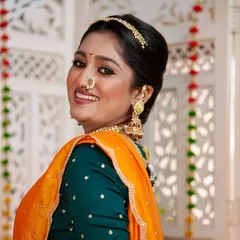 Her smile lights up the frame. The makeup is designed to look radiant and feel comfortable, allowing the bride's personality to shine through.