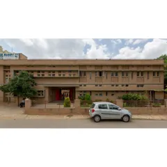 The main entrance of Buddhi School, showcasing the warm texture of compressed stabilised earth block (CSEB) masonry. The entire school is designed to be fully accessible and was built on existing rock to minimize foundation costs and preserve the natural landscape.