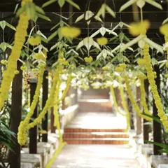 This outdoor walkway at Chairman's Jade resort was decorated for a wedding. I hung garlands of yellow flowers and traditional woven leaf elements from the wooden pergola to create a beautiful path for guests.