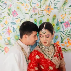 An intimate portrait against a vibrant, hand-painted wall in Udaipur. We use unique details in the decor to create a rich and colorful backdrop that complements the couple's traditional wedding attire.