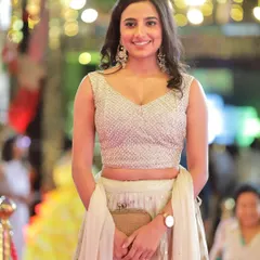 A candid shot of actress Shivani Rai smiling on the red carpet, showcasing her sparkling lehenga and the glamorous atmosphere of the event.