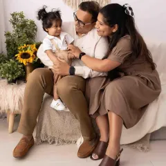 A cozy and candid moment during an indoor family session. The neutral tones and soft lighting create a warm, intimate portrait of this beautiful family.