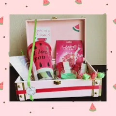 A fun and fresh 'One in a Melon' themed hamper. This trunk box includes a watermelon-themed tumbler, a face mask, and other small, coordinated gifts.