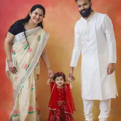 A little Radha with her loving parents. This full-length family portrait from a Janmashtami session shows off their beautiful traditional attire and the sweet family connection.