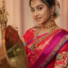 A perfect look for Varalakshmi Vratam or any festive pooja. The model is wearing a beautiful temple jewellery set that pairs wonderfully with her red and pink silk saree.