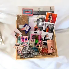 A look at a fully loaded birthday hamper, all arranged in a rustic wooden tray. This gift set includes a custom frame, jhumka earrings, candles, polaroids, scrunchies, and personalized wallet cards.