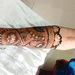 A close-up view of a detailed armband design. This section of a full-arm mehandi showcases intricate work with swans and lotuses, demonstrating the fine details I include in my larger pieces.