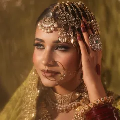 This angle showcases the stunning headpiece and the detailed eye makeup. The soft contour and highlight enhance the model's features, creating a look of pure elegance.
