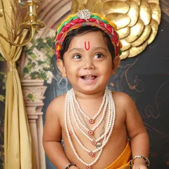 The pure, innocent smile of a little one dressed as Kanha is truly divine. This close-up from a Janmashtami themed shoot captures the joyful spirit that makes these sessions so special.