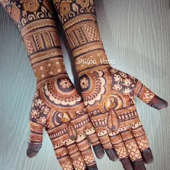 This full-hand bridal design features a mix of traditional peacock motifs and circular mandala patterns, extending into a beautifully detailed cuff.