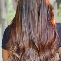 This is a perfect example of a warm, golden-hour balayage. The caramel and honey tones are painted onto long hair, creating a beautiful, sun-kissed effect that looks effortless.