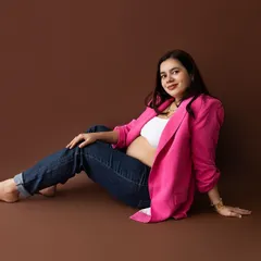 A relaxed and modern pose with the mom-to-be seated on the floor, showcasing a chic and comfortable pregnancy style.