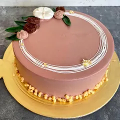 This is our minimalist rosette cake, a simple yet elegant design. It features a smooth chocolate frosting, delicate white line work, and small chocolate rosettes for a sophisticated finish.