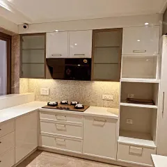 A detailed shot of the cooking zone. The four-burner hob is set against a beautiful mosaic tile backsplash, with open shelving on the side for easy access to everyday items.