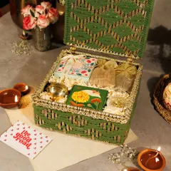 A closer look at our green and gold woven Diwali hamper. It includes a beautiful urli, aromatic tea pouches, and other festive treats, all nestled in a reusable basket.