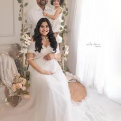 A glowing mother-to-be with her husband and daughter, eagerly awaiting the new arrival. This maternity portrait, styled in all-white, is a beautiful celebration of a growing family.