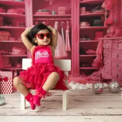 It's a Barbie world, and this little one owns it. My Barbie-themed shoots are all about capturing that fun, confident personality with a vibrant pink set and stylish props like these heart-shaped sunglasses.
