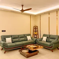 This living room uses layered lighting, including ceiling cove lights and spotlights, to create a warm and inviting space. The smart panel is visible on the wall for easy control.