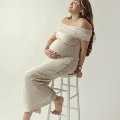A moment of pure, uninhibited joy. This mom to be leans back with a radiant smile, embracing the happiness and excitement of her pregnancy.