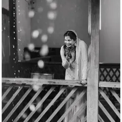 A beautiful, candid black and white shot of the bride sharing a laugh. The bokeh effect from the lights adds a touch of magic to this spontaneous moment of happiness.