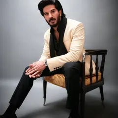 A full-length shot of Dulquer Salmaan's GQ look. The cream and black combination is a timeless choice for formal menswear, offering a sophisticated contrast.