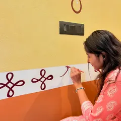 Here I am carefully painting traditional rangoli-style patterns at a client's house entrance. These minimal designs add a touch of elegance and cultural heritage to the home's entryway.