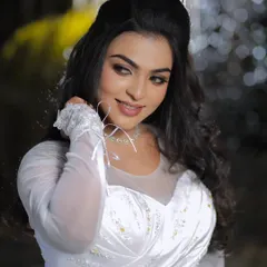 A beautiful portrait of a bride in her white gown. The makeup is soft and glowing, with a focus on her expressive eyes.