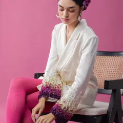 A full look from an avant-garde series, this image combines a sharply tailored blazer with bold, colorful tights. The contrast between the structured jacket and the vibrant legwear, along with the floral headpiece, creates a visually arresting, high-fashion statement.
