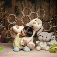 A playful hug with a big teddy bear during a whimsical studio shoot. We encourage kids to interact with props and toys to bring out their natural smiles and playful nature.