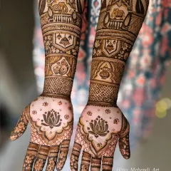 This is a classic Maharashtrian bridal design, rich with traditional motifs. It features auspicious symbols like elephants in a procession, a sacred kalash, and beautiful lotus patterns on the palms for a truly timeless look.