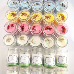 An overhead view of the assorted wedding candles, showing the variety of colors and toppings like lavender buds, seashells, cinnamon, and rose petals.