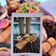 A creative polaroid shot of a poolside grazing platter. This image captures the fun and relaxed vibe of the event while highlighting the beautiful food display.