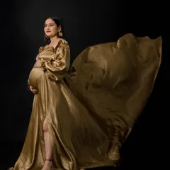 Go for gold with our glamorous Taylor gown. This two-piece satin ensemble features dramatic balloon sleeves and a flowing skirt with a slit, creating a show-stopping goddess look that's sure to turn heads.