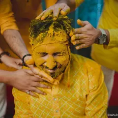 The groom gets his turn, being playfully covered in haldi by his friends and family.
