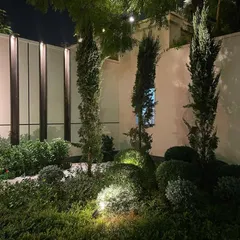 The right lighting can transform a garden at night. For this high-end farmhouse project, I used strategic uplighting to highlight the form of cypress trees and manicured shrubs, creating a dramatic and elegant evening ambiance.