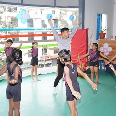 A coach leads a warm-up session for a group of gymnasts, getting them ready for a fun and productive class.
