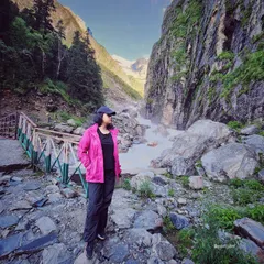 A moment of reflection by a rushing mountain stream. This outfit, with a bright pink waterproof jacket, is styled for both adventure and stunning photo opportunities.