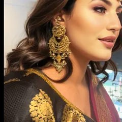 This is a classic traditional wedding guest look. It features defined eyes with kajal, glowing skin, and a lip color that perfectly complements the rich tones of her ethnic wear.